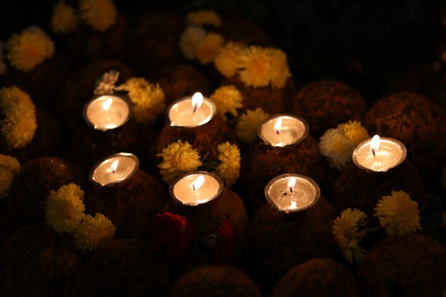 Several softly glowing candles surrounded by flowers create a warm and comforting scene for direct cremation Columbus, OH